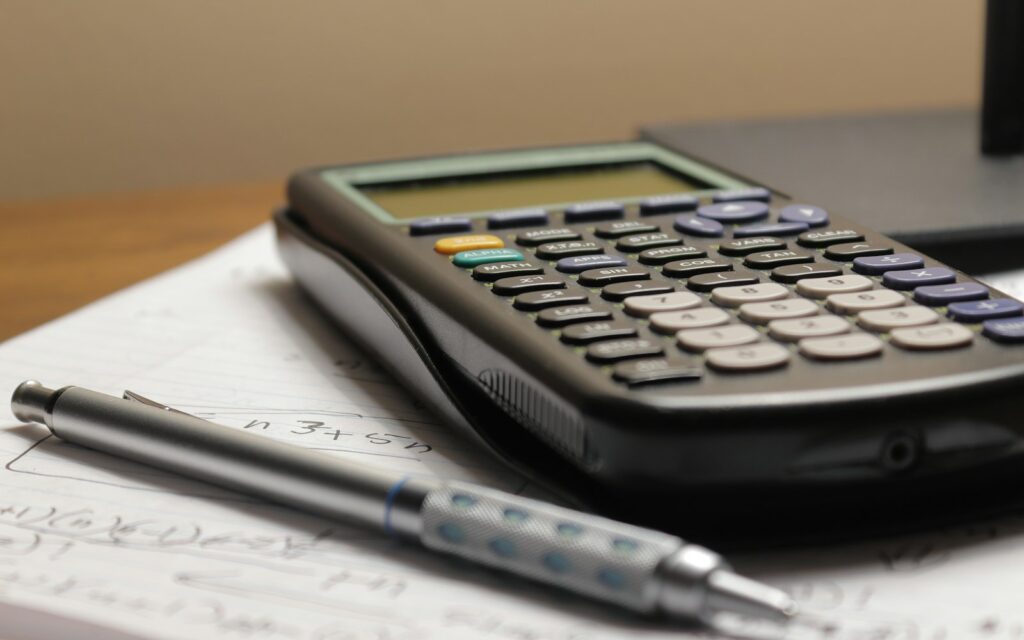 a calculator and a pen sitting on top of a piece of paper